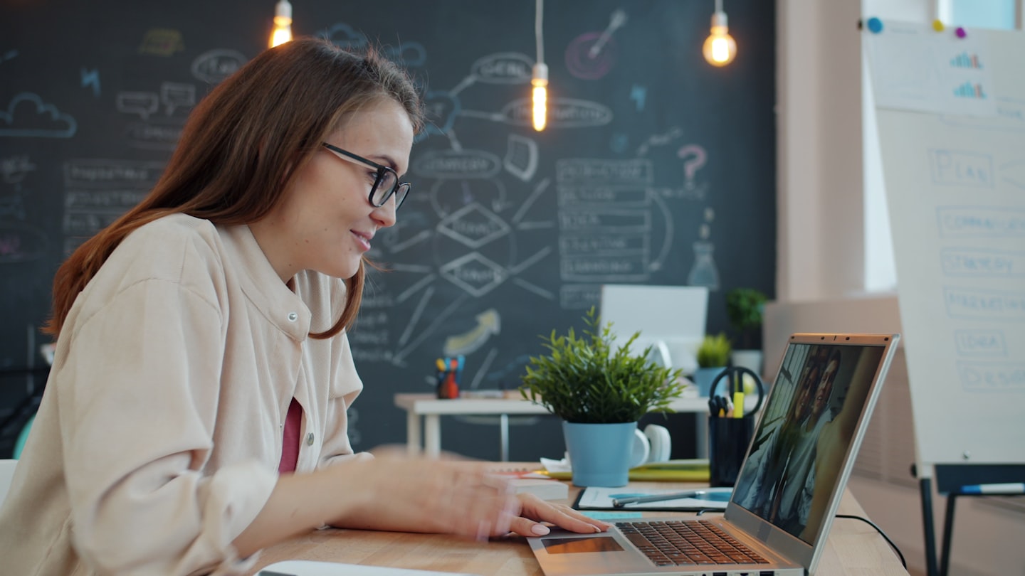 Woman working on a laptop in a modern office.