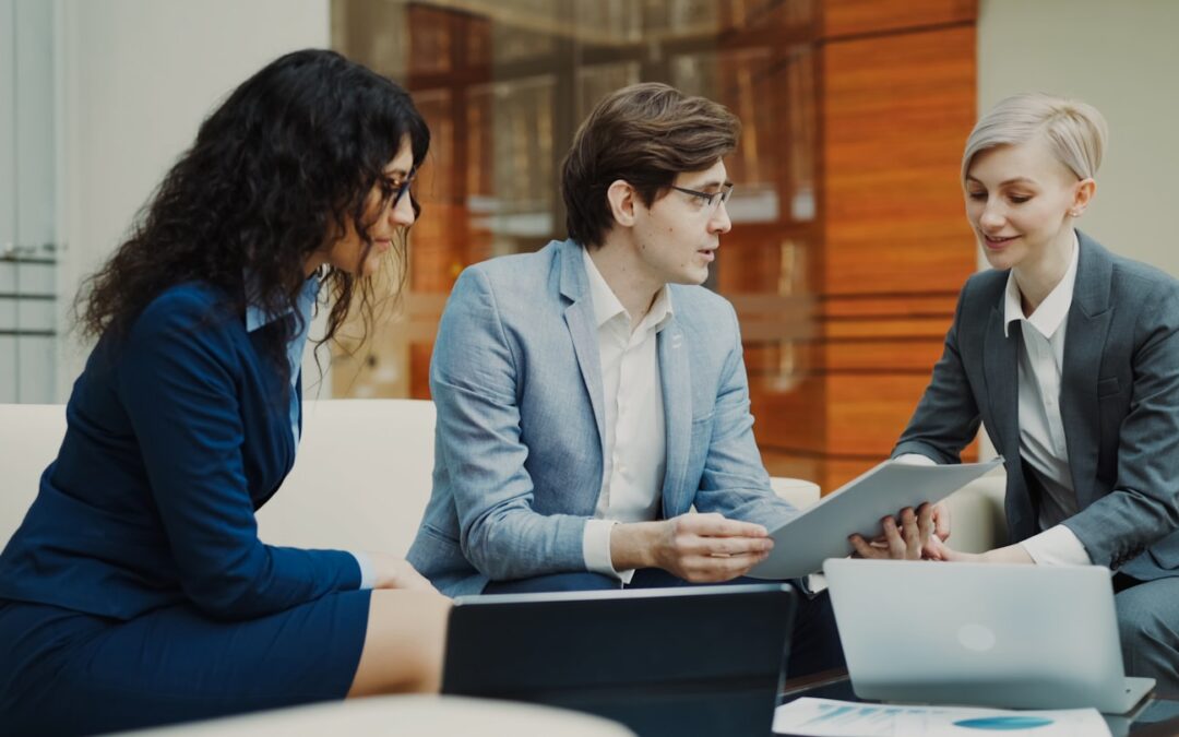 Three professionals discussing documents at a table.