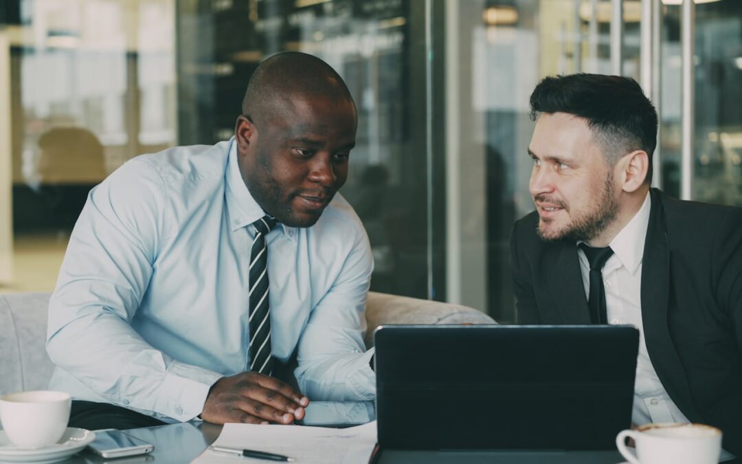 Two businessmen discussing documents at a table.