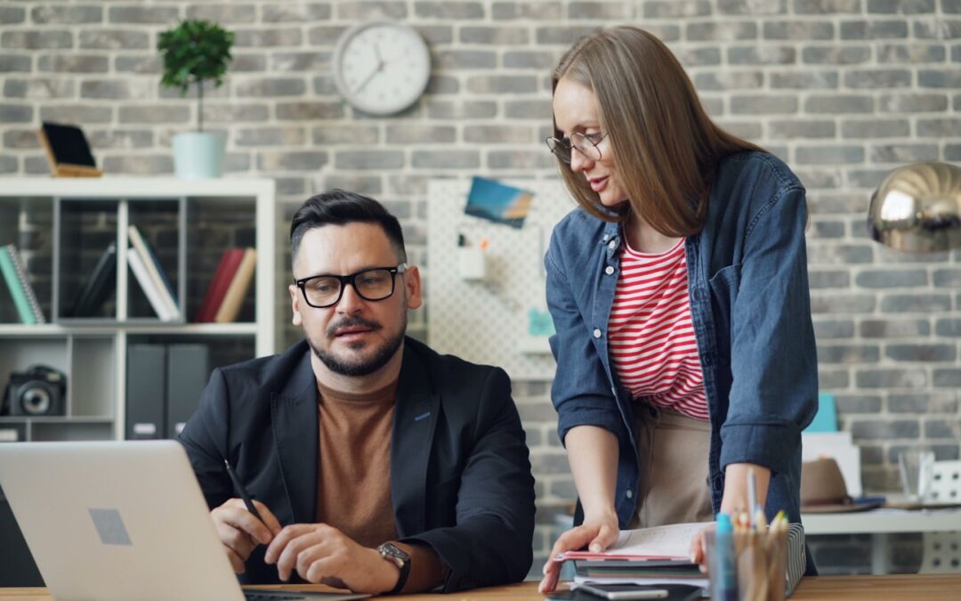 a man and a woman looking at a laptop