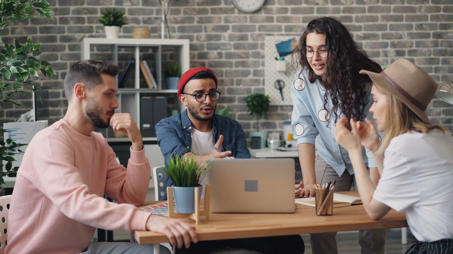 a group of people sitting around a wooden table