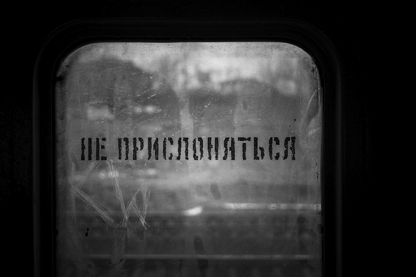 A black and white photo of a window with the words, the impecio