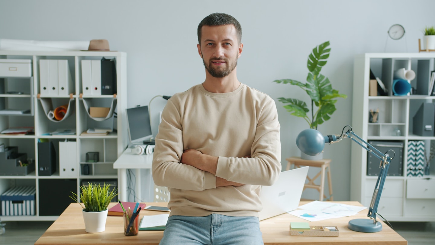 Man with arms crossed in modern office workspace