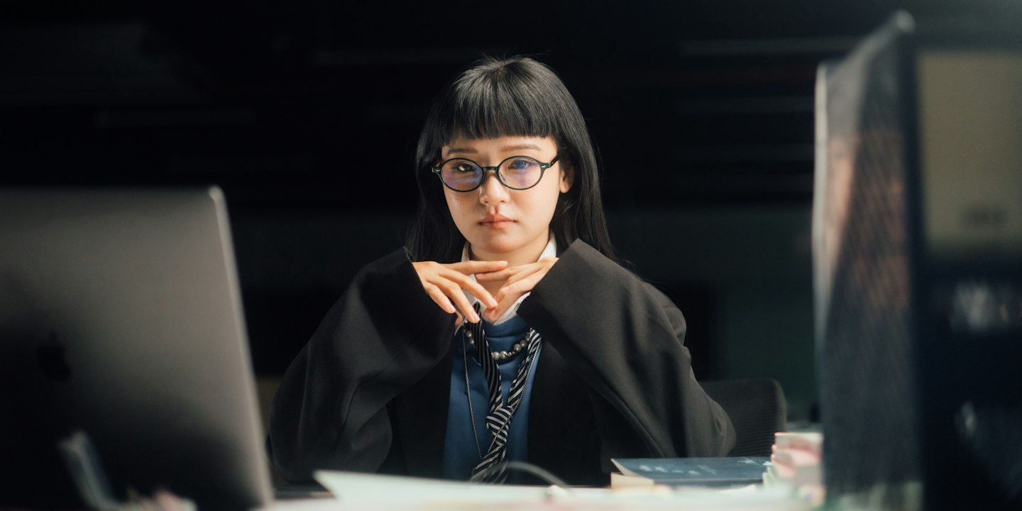 A woman looks pensive at her work desk